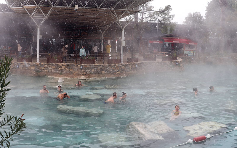 Pamukkale’de turistler kar yağarken antik havuzun keyfini çıkardı
